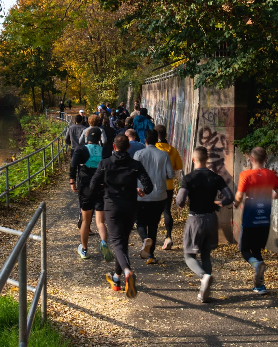 Runners along the river in autumn light