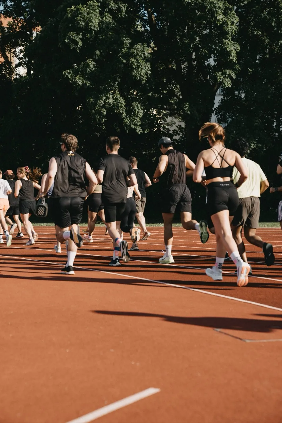 The crew running on a red athletics track